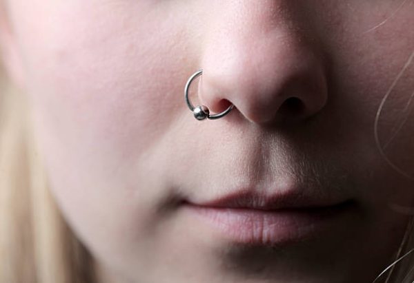 Closeup of a pretty girl's visage with a piercing hanging from her nose